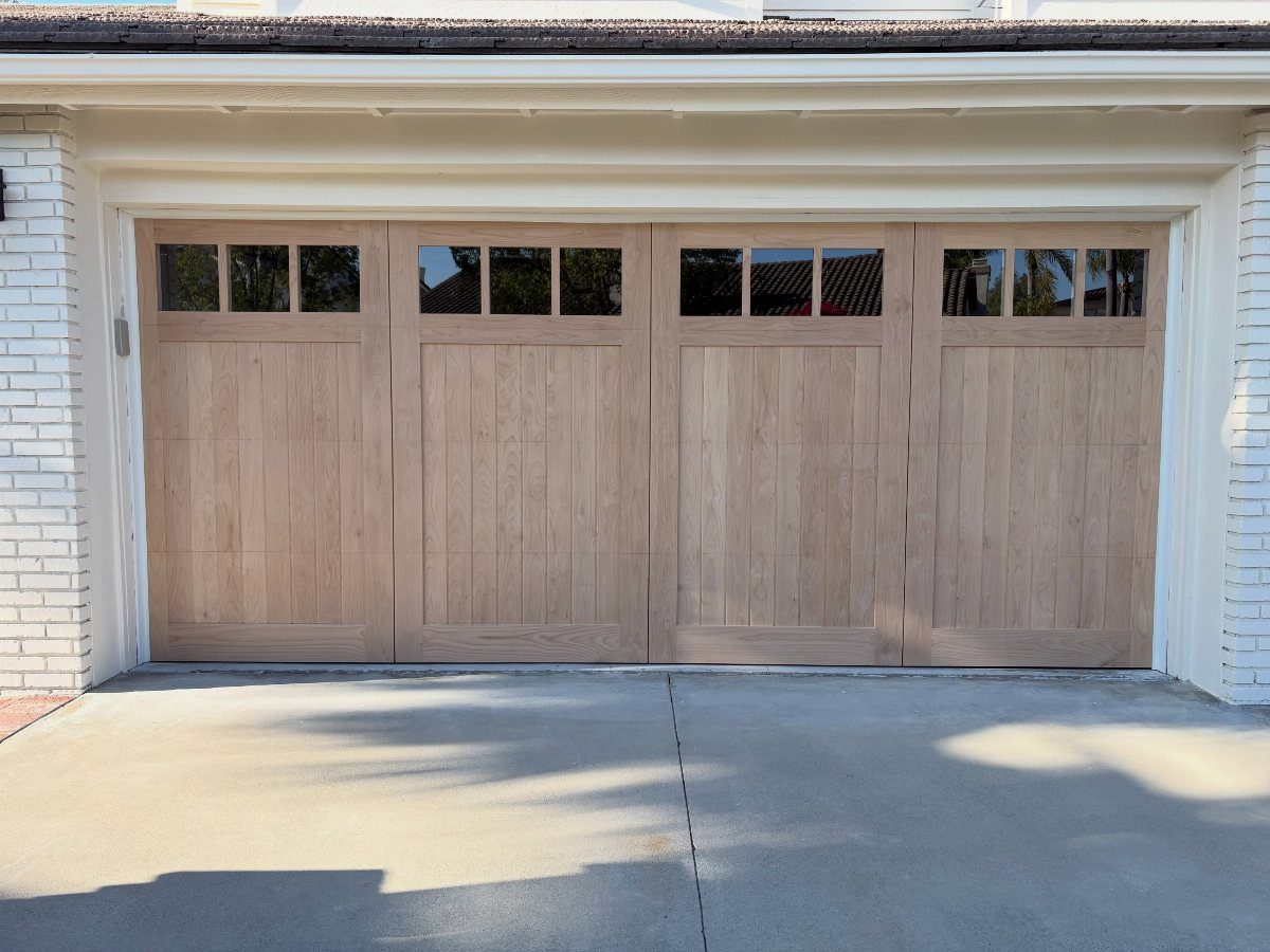 American House Garage Door: 7 Styles for Better Curb Appeal 7 Light wood garage door with small windows at the top on a white house.
