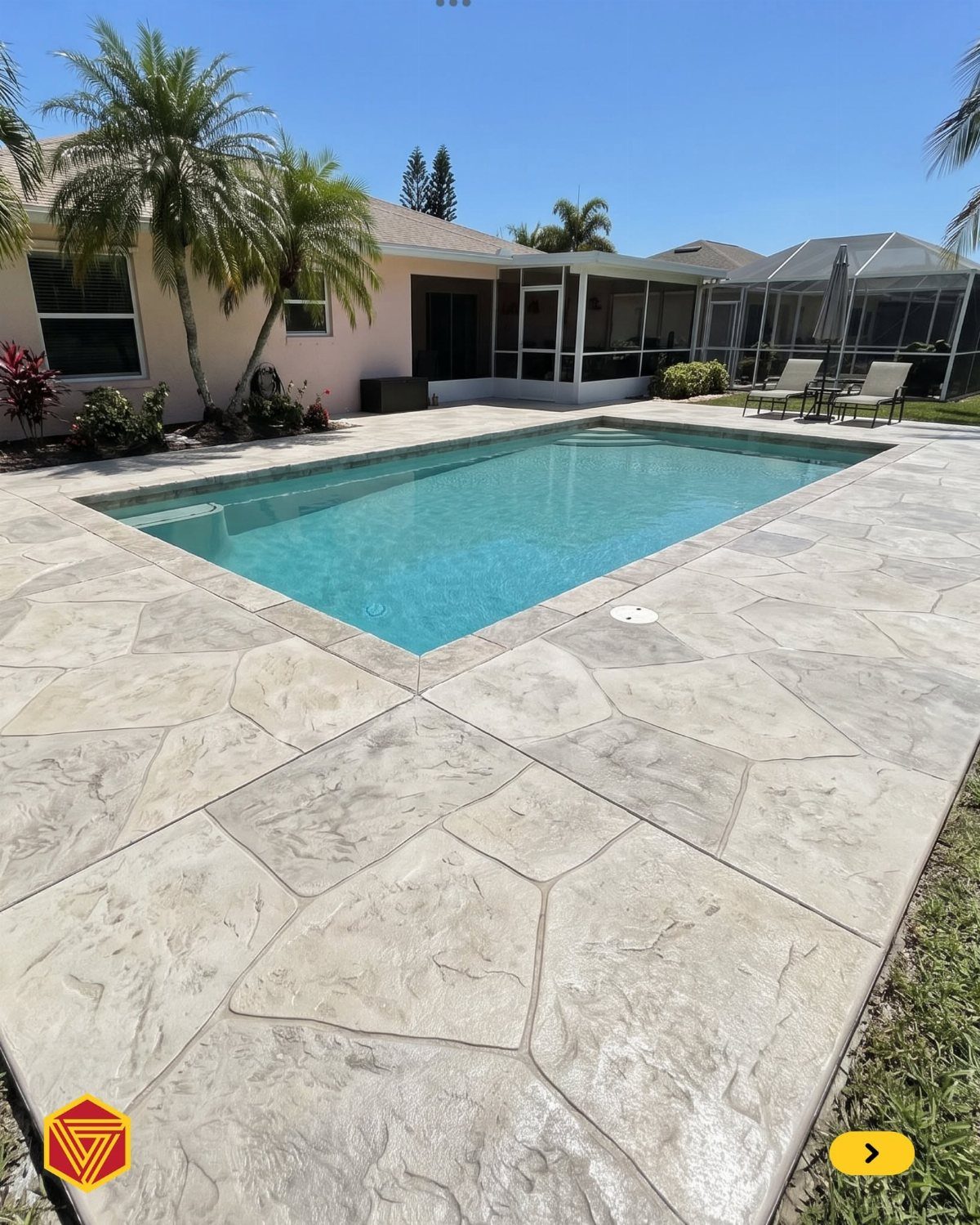 Stamped concrete pool deck with a large stone pattern surrounding a turquoise swimming pool.