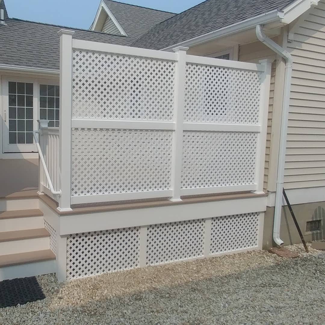 White lattice privacy panels installed on a wooden deck next to a house.