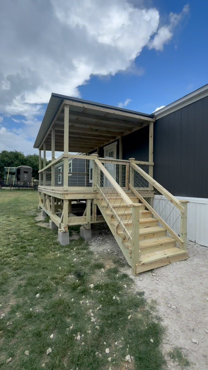 Deck Steps With Landing: 12 Ideas for Any Yard 12 Wooden deck stairs with a landing and a covered roof attached to a dark grey building.