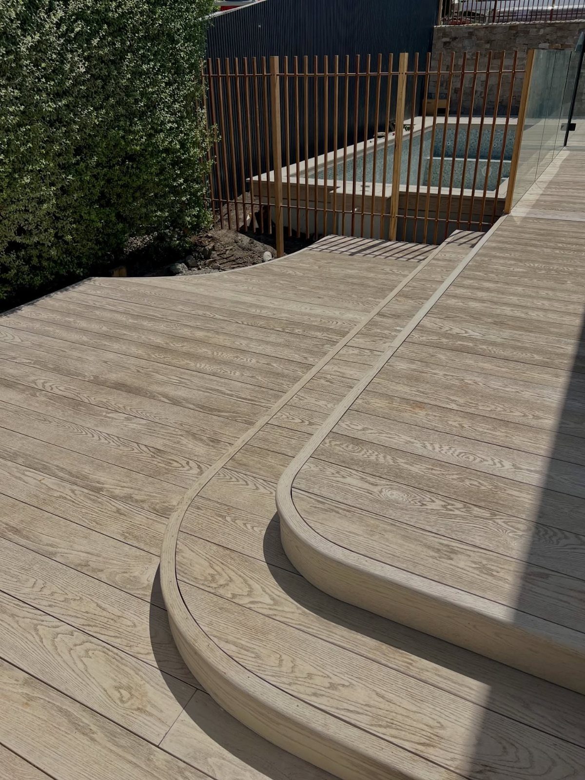 Deck Steps With Landing: 12 Ideas for Any Yard 2 Curved composite deck steps with a matching rounded edge on a light brown wooden platform.