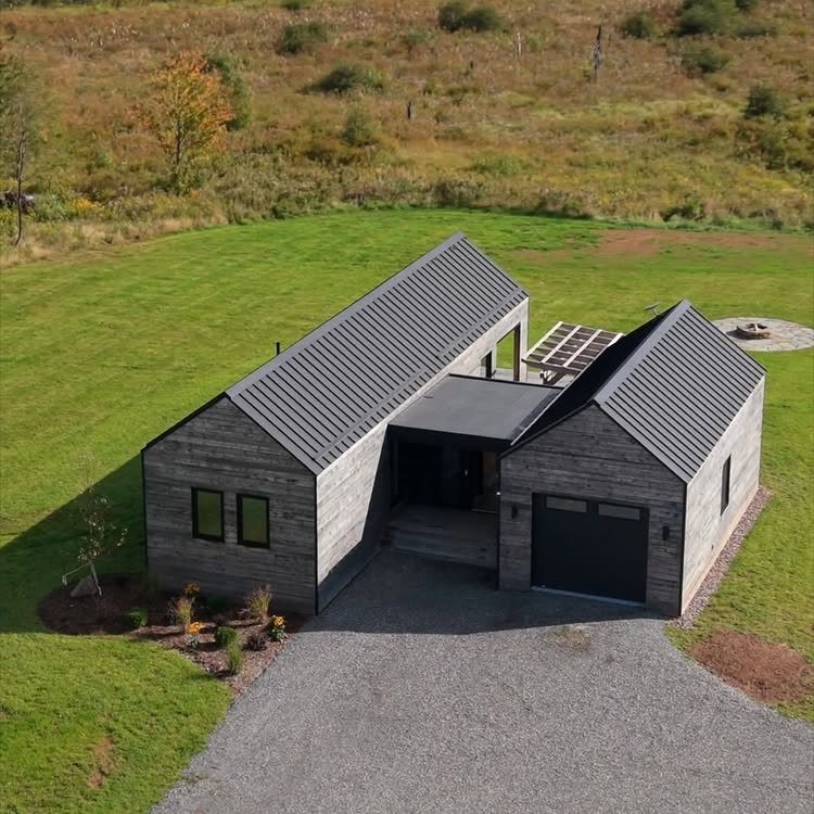 Detached Garage with Breezeway to House: 8 Ideas 3 Modern grey wooden house and garage connected by a dark enclosed breezeway under a clear sky.
