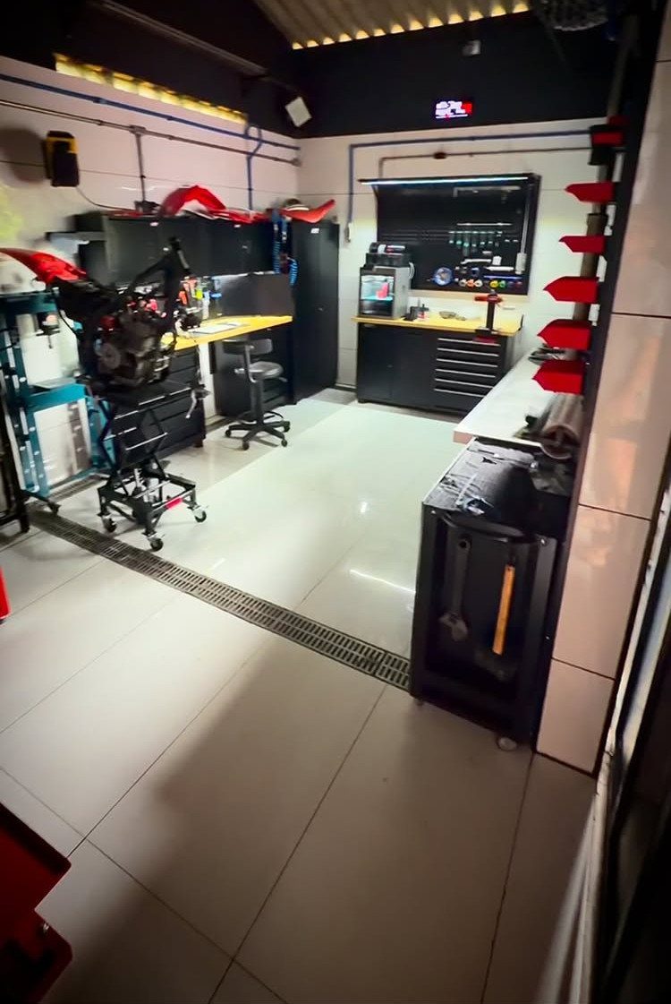Detached Garage with Breezeway to House: 8 Ideas 2 A clean, modern garage workshop featuring a motorcycle engine on a lift and organized black tool cabinetry.