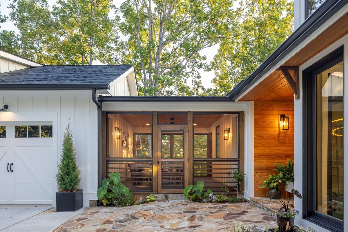 Detached Garage with Breezeway to House: 8 Ideas 5 A covered glass breezeway connecting a white garage to a modern wood-sided house.