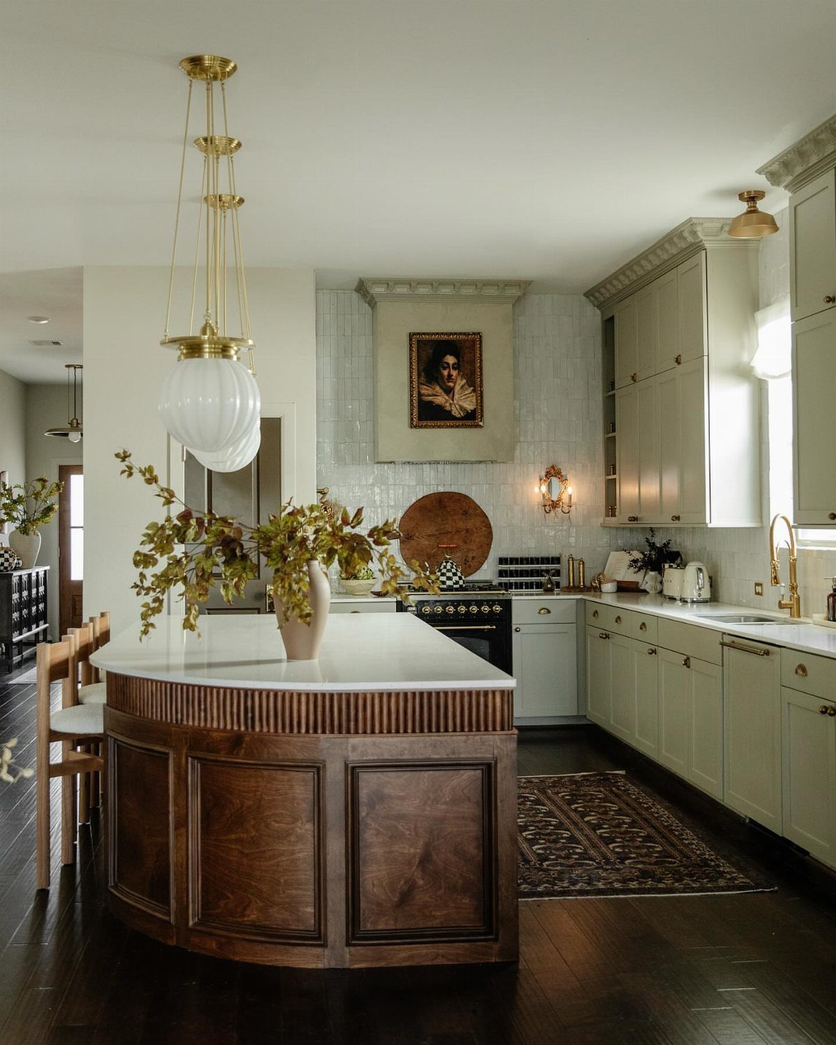 17 DIY Kitchen Island Ideas From Dressers to Live-Edge Slabs 13 A large curved wooden kitchen island with a white marble top in a bright kitchen.