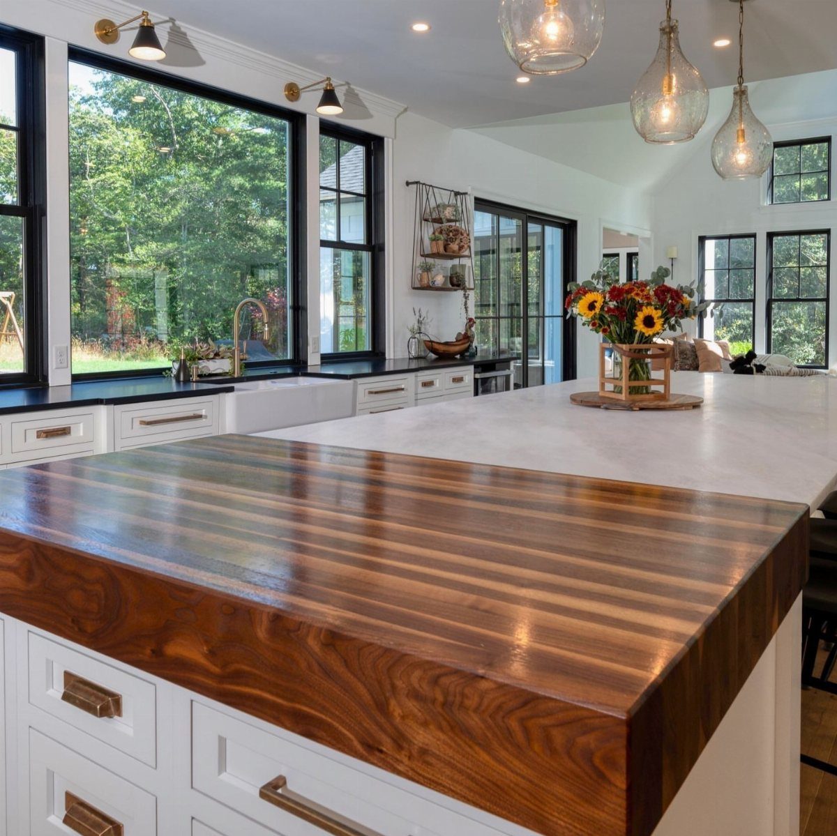 17 DIY Kitchen Island Ideas From Dressers to Live-Edge Slabs 16 A kitchen island featuring a dark wood butcher block and white marble countertop with white cabinets.