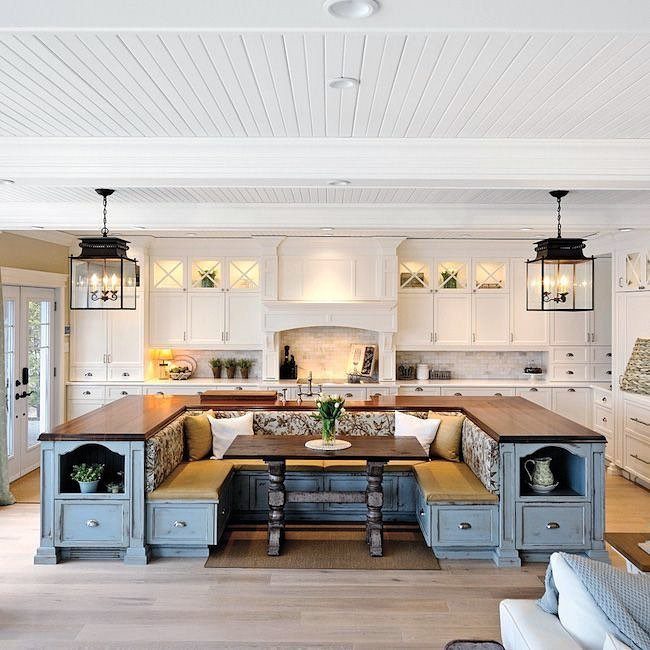 17 DIY Kitchen Island Ideas From Dressers to Live-Edge Slabs 15 A large custom wooden kitchen island with built-in blue cabinetry and U-shaped banquette seating.