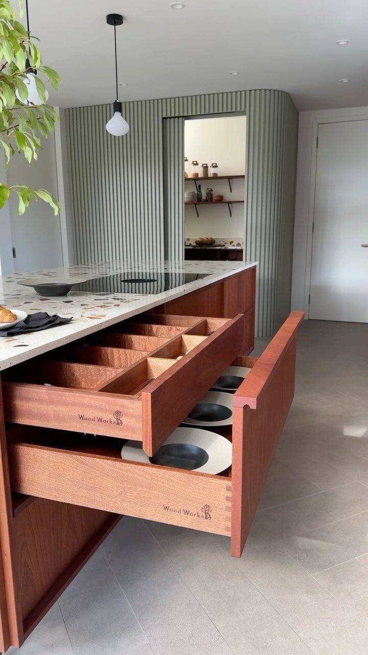 17 DIY Kitchen Island Ideas From Dressers to Live-Edge Slabs 17 Open wooden drawers in a modern kitchen island showing organized storage compartments.