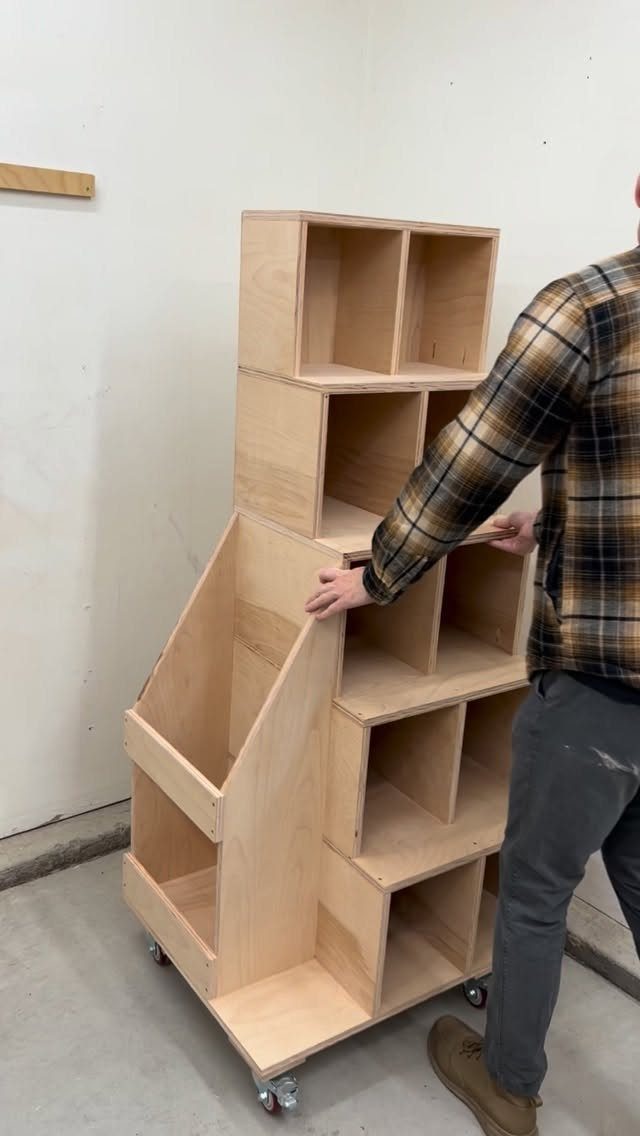 A tall wooden shelving unit with multiple open compartments on caster wheels.