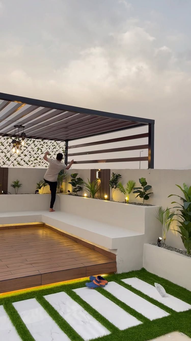 Garage Rooftop Deck: 8 Ideas for Your Space Above 7 Modern rooftop deck with wooden flooring, white built-in benches, a pergola, and artificial grass pavers.