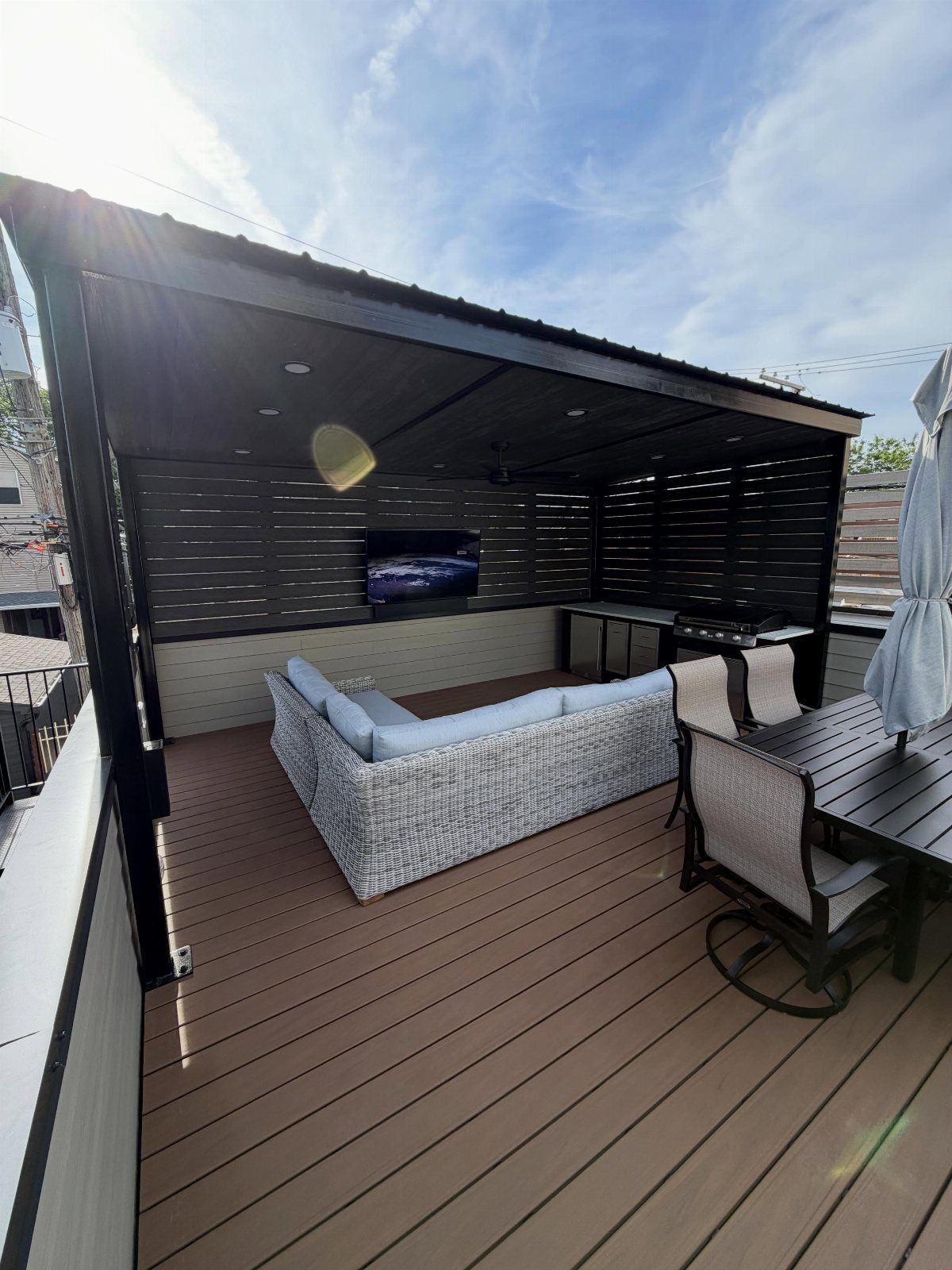 Garage Rooftop Deck: 8 Ideas for Your Space Above 1 A modern rooftop deck with wicker seating, a dining set, and an outdoor kitchen area.
