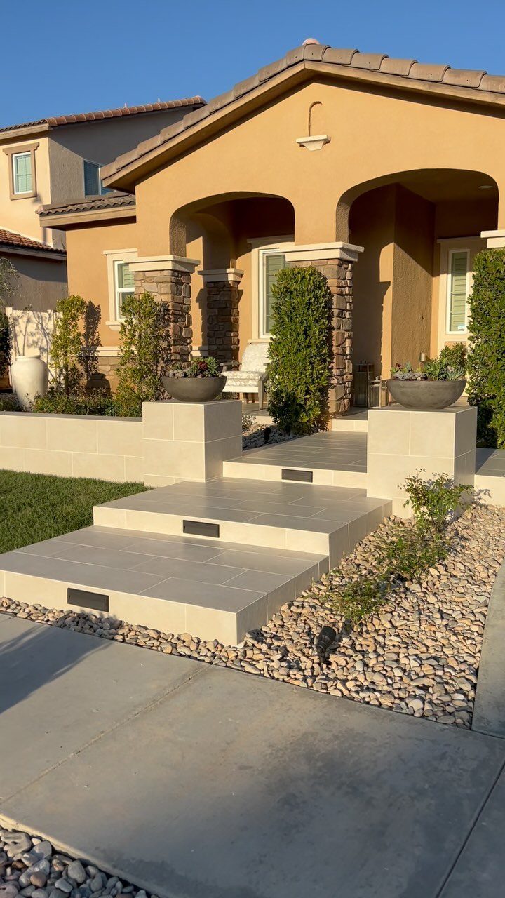 11 Landscaping Front Walkway Ideas: Flagstone to Paver & Modern Styles 9 Large light porcelain tiles forming wide steps leading to a modern house entrance.
