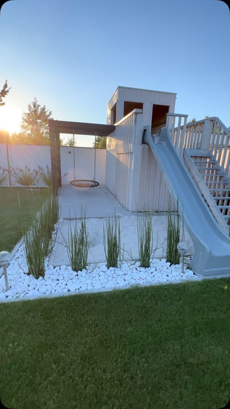 18 Yard Layout Ideas with Photos for Front and Back Spaces 18 Wooden playset with a slide and swing set situated on a concrete patio area.